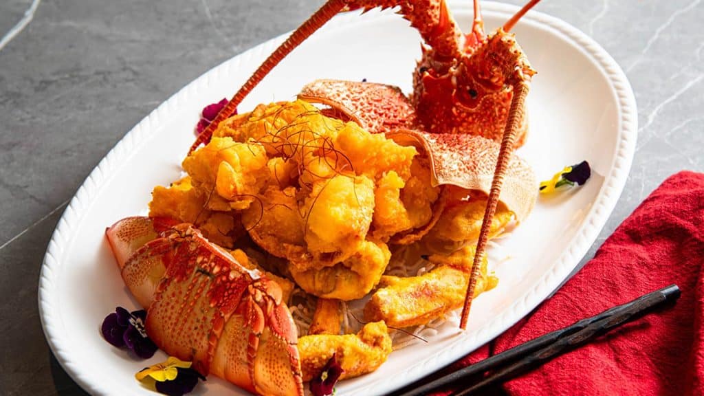 Crispy lobster served with the head and edible flowers at Horizon, a Chinese restaurant in Cabramatta