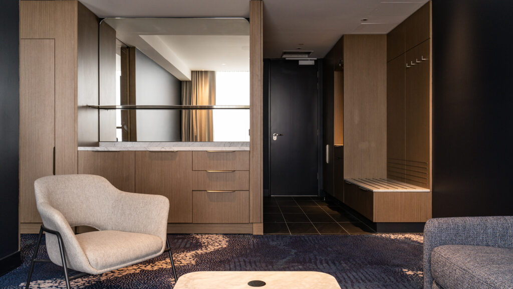 Spacious living area in the Presidential Suite at Novotel Sydney Cabramatta, featuring lounge seating, wardrobe and vanity.