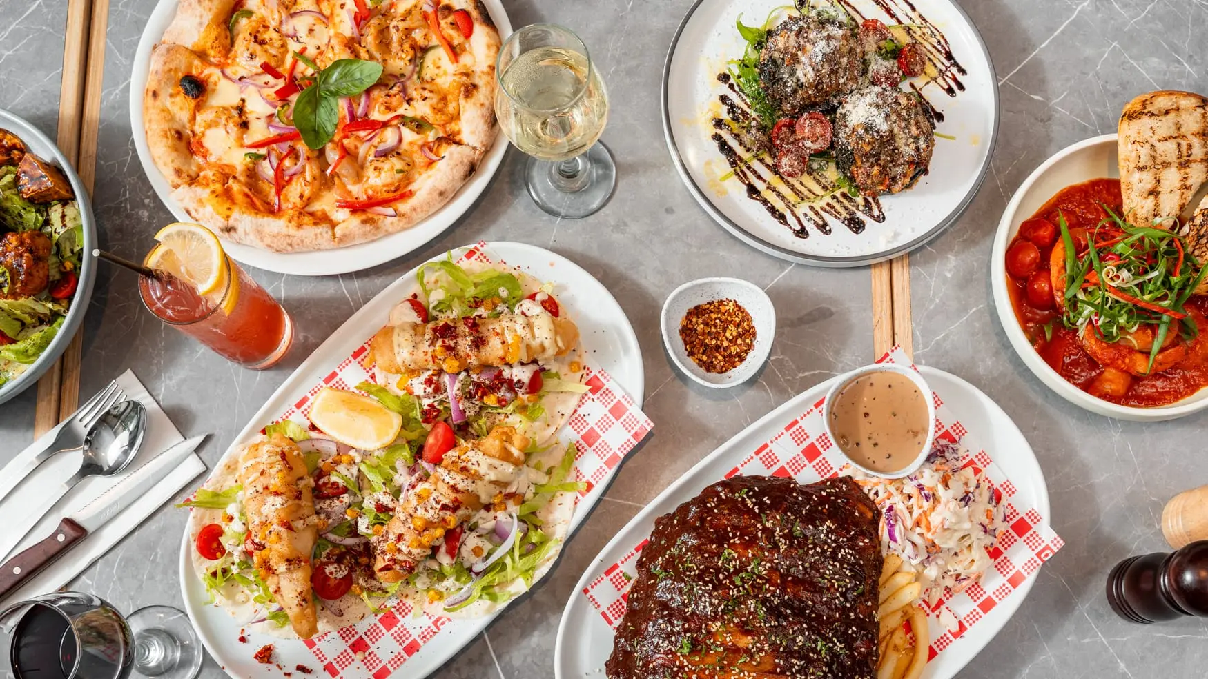 Bistro 1925 spread at Cabravale Club Resort showing fish tacos, garlic prawns, wood fired pizza and BBQ ribs