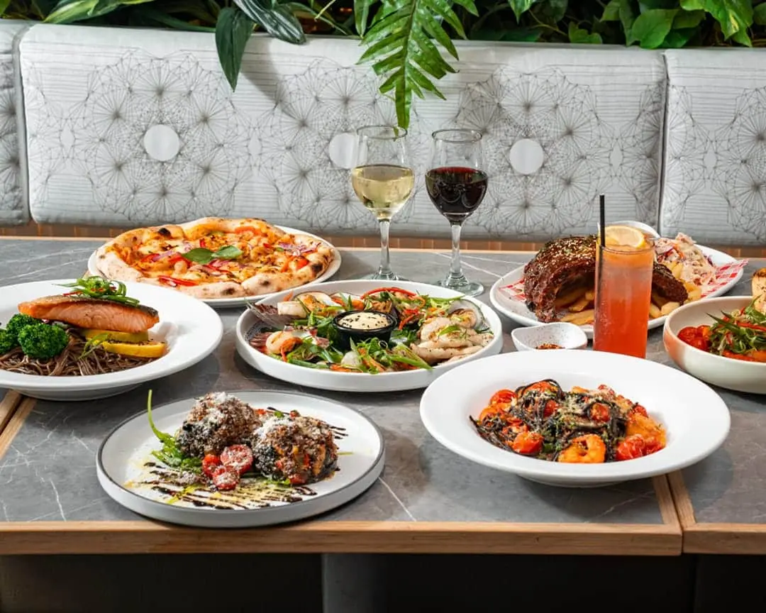 Assorted Bistro 1925 dishes including pizza, seafood platter, black linguine with prawns and BBQ pork ribs