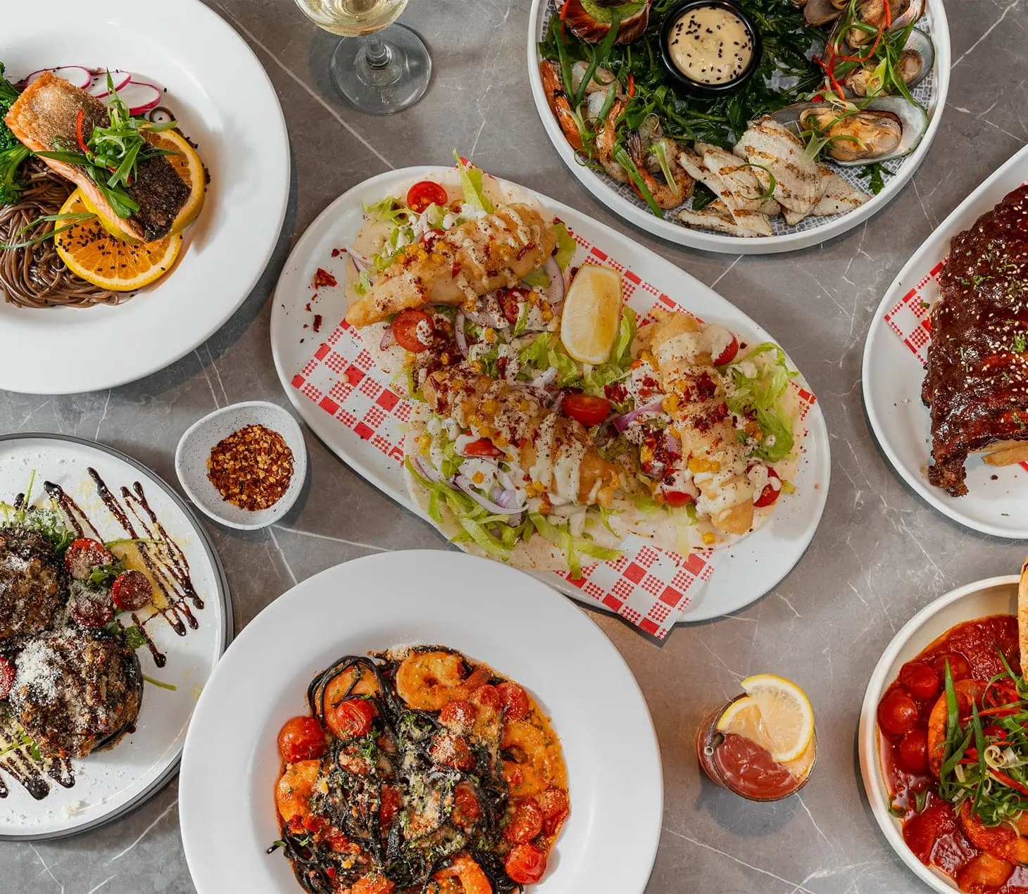 Bistro 1925 Cabramatta table spread with battered fish tacos topped with corn, lettuce, tomato, red onion and tartare sauce