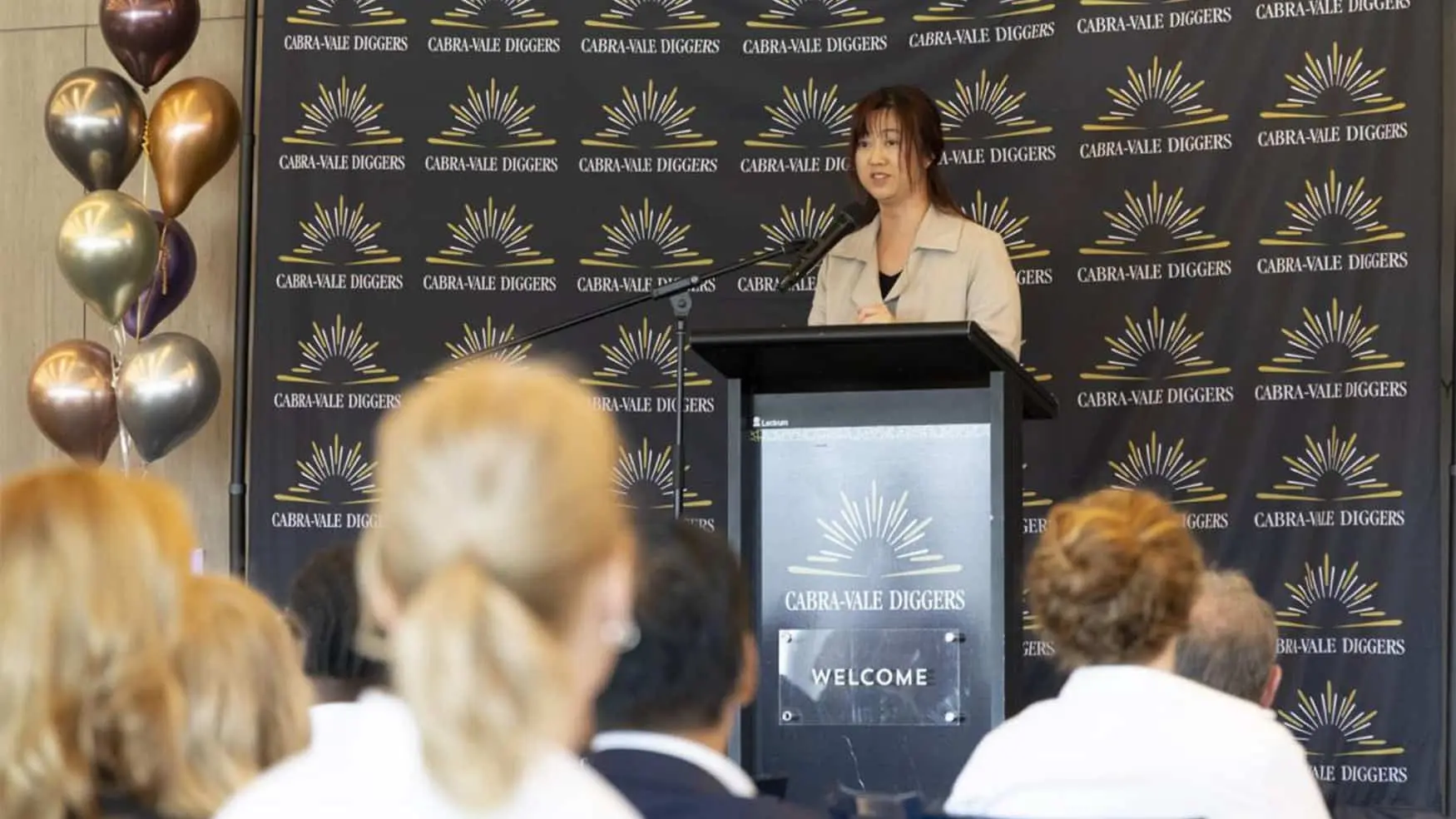 Speaker addressing attendees at the Cabravale Club Resort ClubGRANTS Presentation at Cabravale, standing at a podium in front of a Cabravale Diggers branded backdrop.