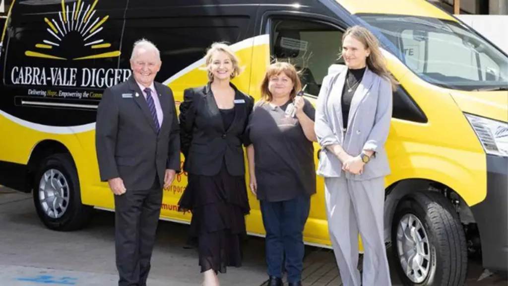 Cabravale and Community Café Inc members beside the yellow van donated through ClubGRANTS