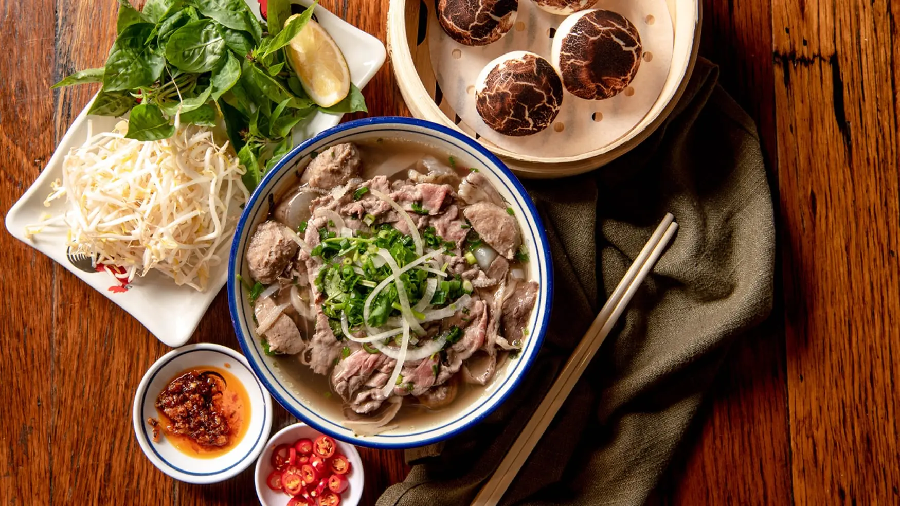 Steaming bowl of pho with fresh herbs and noodles served at District 8 Southeast Asian dining in Canley Vale.