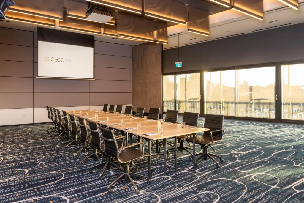 Boardroom table, presentation screen and natural light in a corporate function venue in South West Sydney