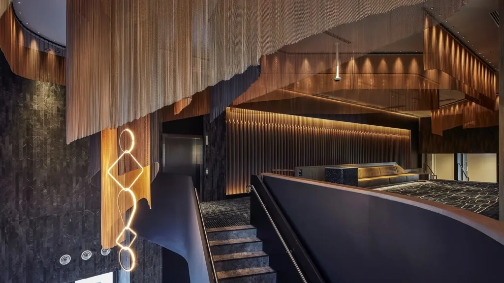Timber-lined foyer with sculptural lighting and curved stairways at the Cabravale Events & Conference Centre