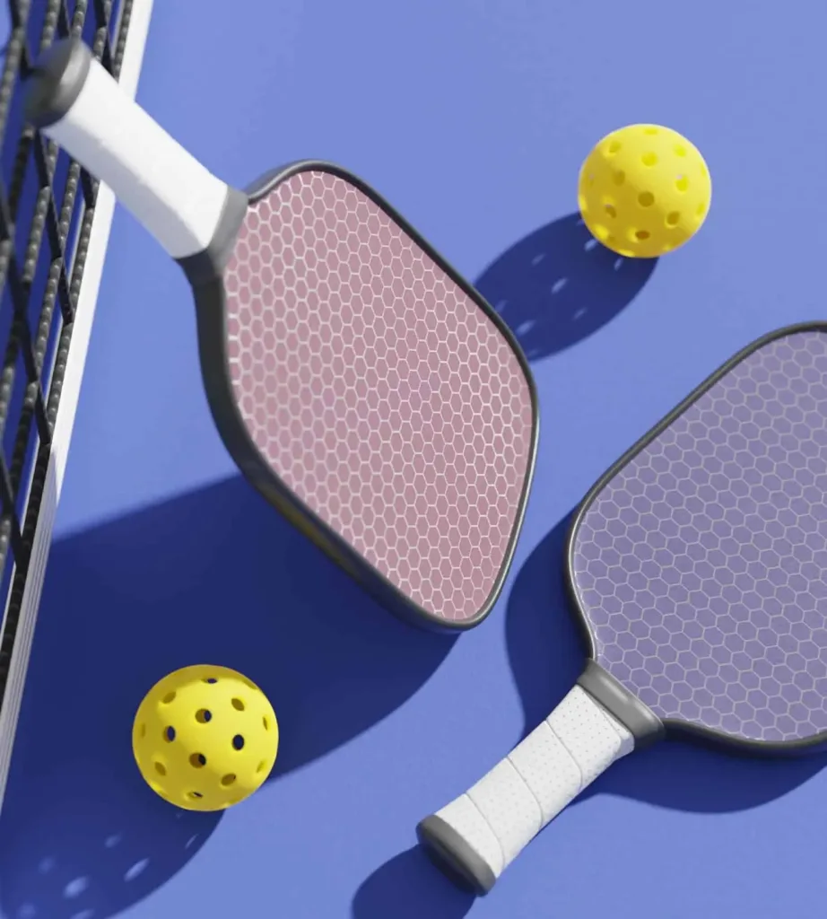 Pickleball paddles and yellow balls on a blue court, part of the local pickleball scene to explore near Cabravale