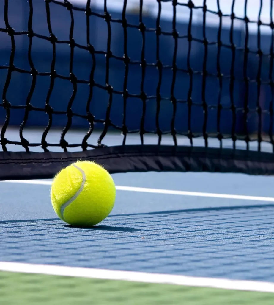 Tennis ball beside the net on an outdoor court, one of the local tennis courts to explore near Cabravale