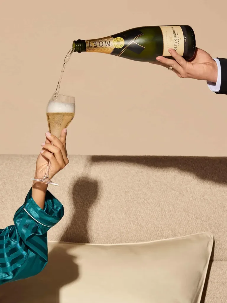 Champagne poured into a glass held by a guest in a satin robe, unwinding at the hotel in Canley Vale