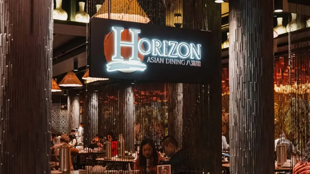 Horizon Asian Dining venue interior showing illuminated sign, seating area, and ambient lighting.