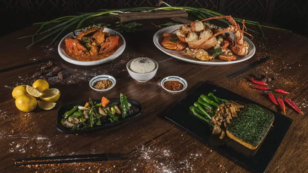 A sharing table with seafood platters, vegetable sides, dipping bowls, lemons, and chopsticks at Horizon Asian Dining