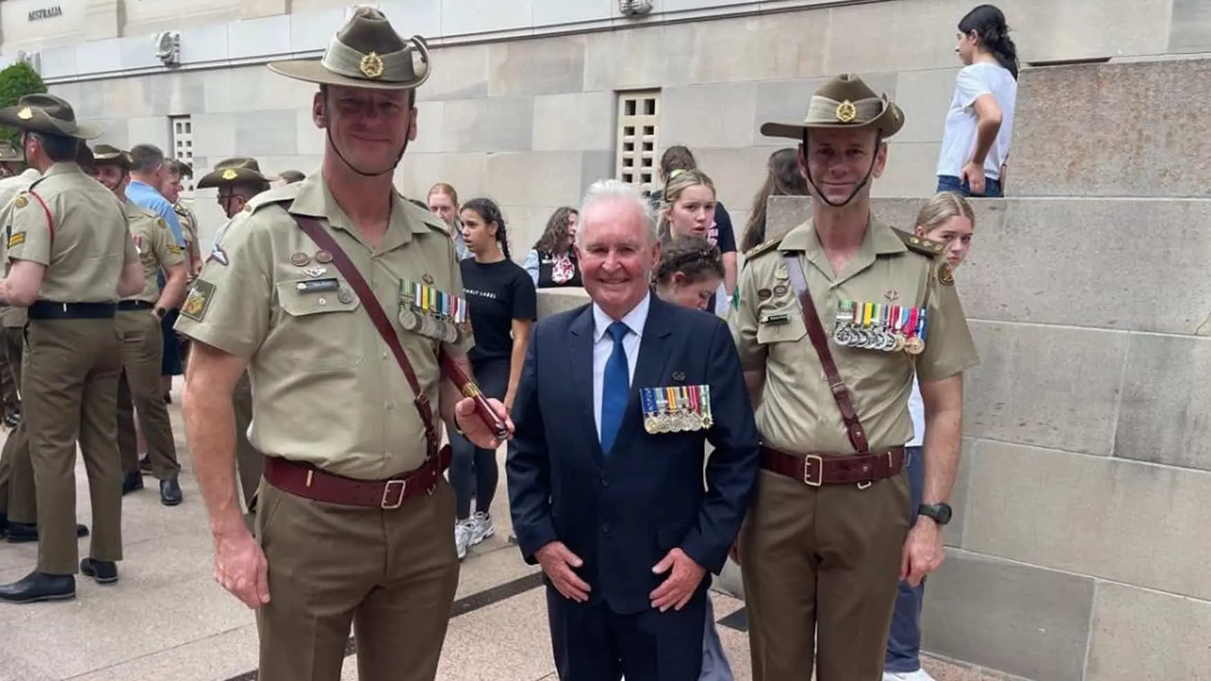 Cabravale Club Resort President Walter Robinson OAM stands with Australian soldiers wearing medals at the Australian War Memorial.