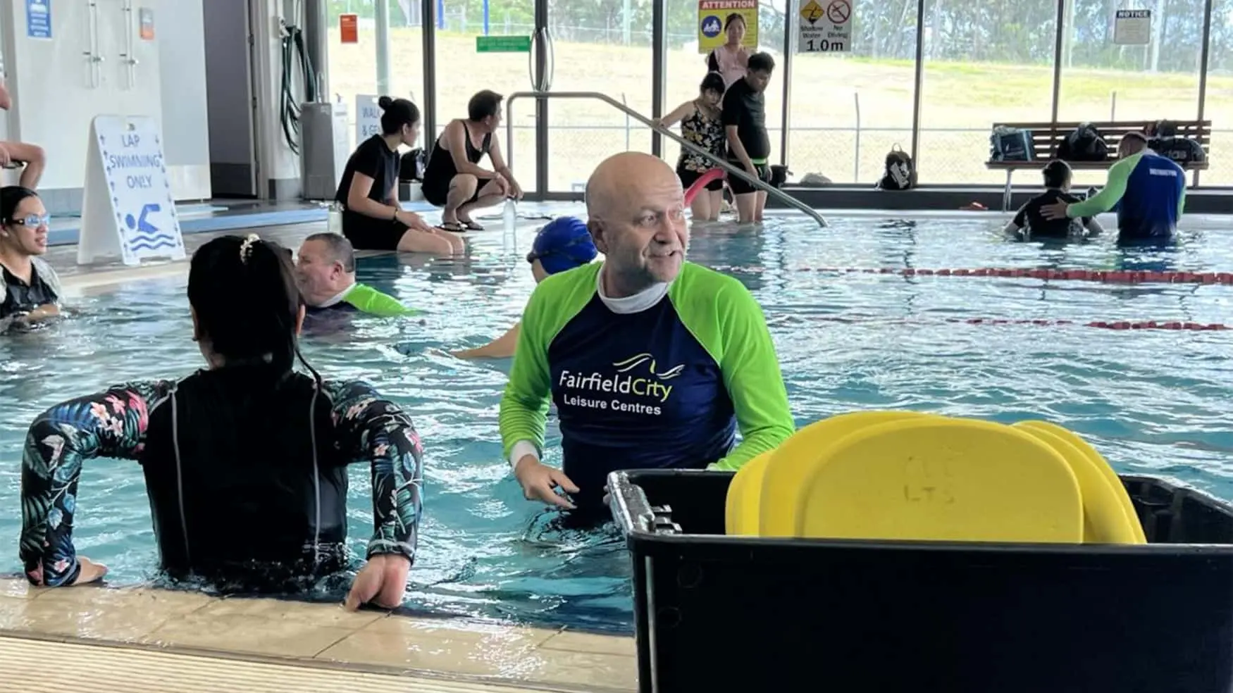 Swim instructor guides adult participants during a Learn to Swim session at a Fairfield leisure centre pool.