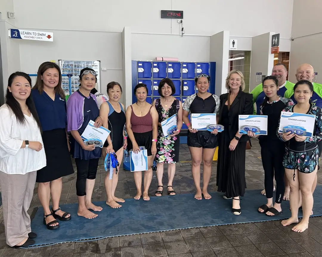 CALD community participants hold certificates at a learn to swim program, at Cabravale Club Resort