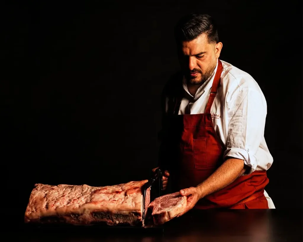 Chef Dany Karam cutting premium beef in the kitchen