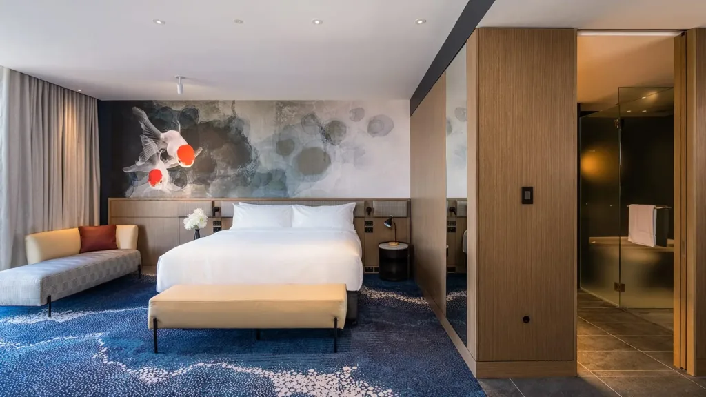 Superior King room with plush bed, lounge seating, koi wall art, and glass bathroom at Novotel Sydney Cabramatta