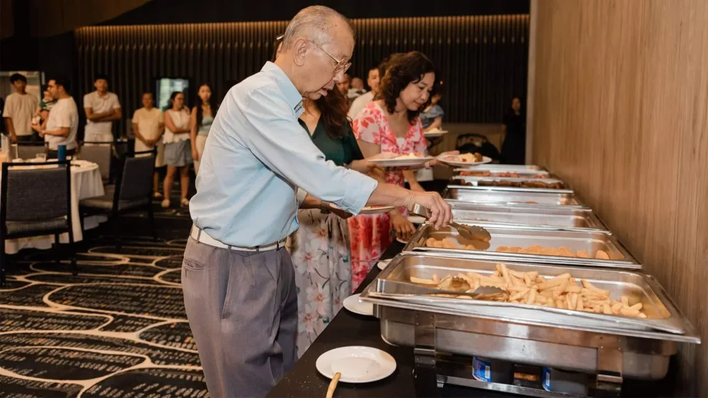 Guests queuing at a catered buffet during a private celebration held in a restaurant function room in Western Sydney