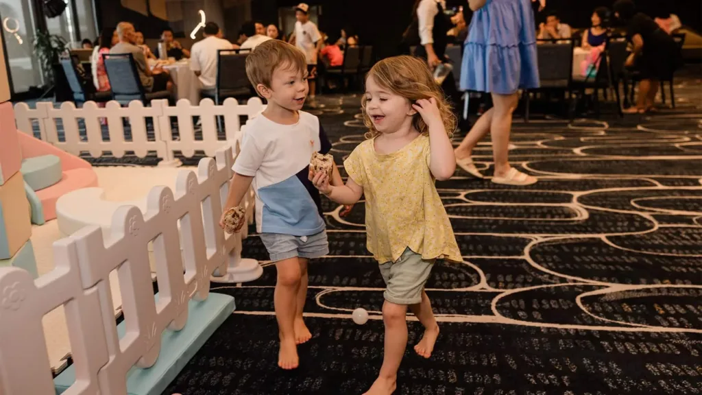 Two young children walking past a pastel soft play area at a private family function at Cabravale