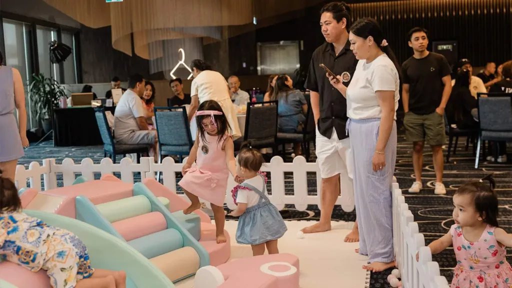 Parents watching children in a soft play area inside a function room set up for private functions
