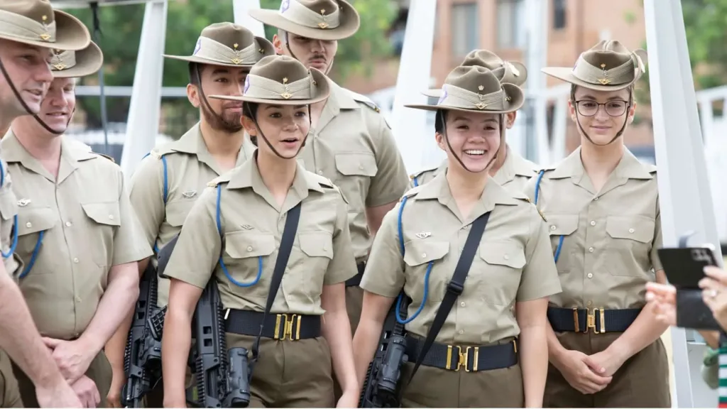 Young Australian Army members in uniform smile and gather together, reflecting pride and camaraderie at the service.
