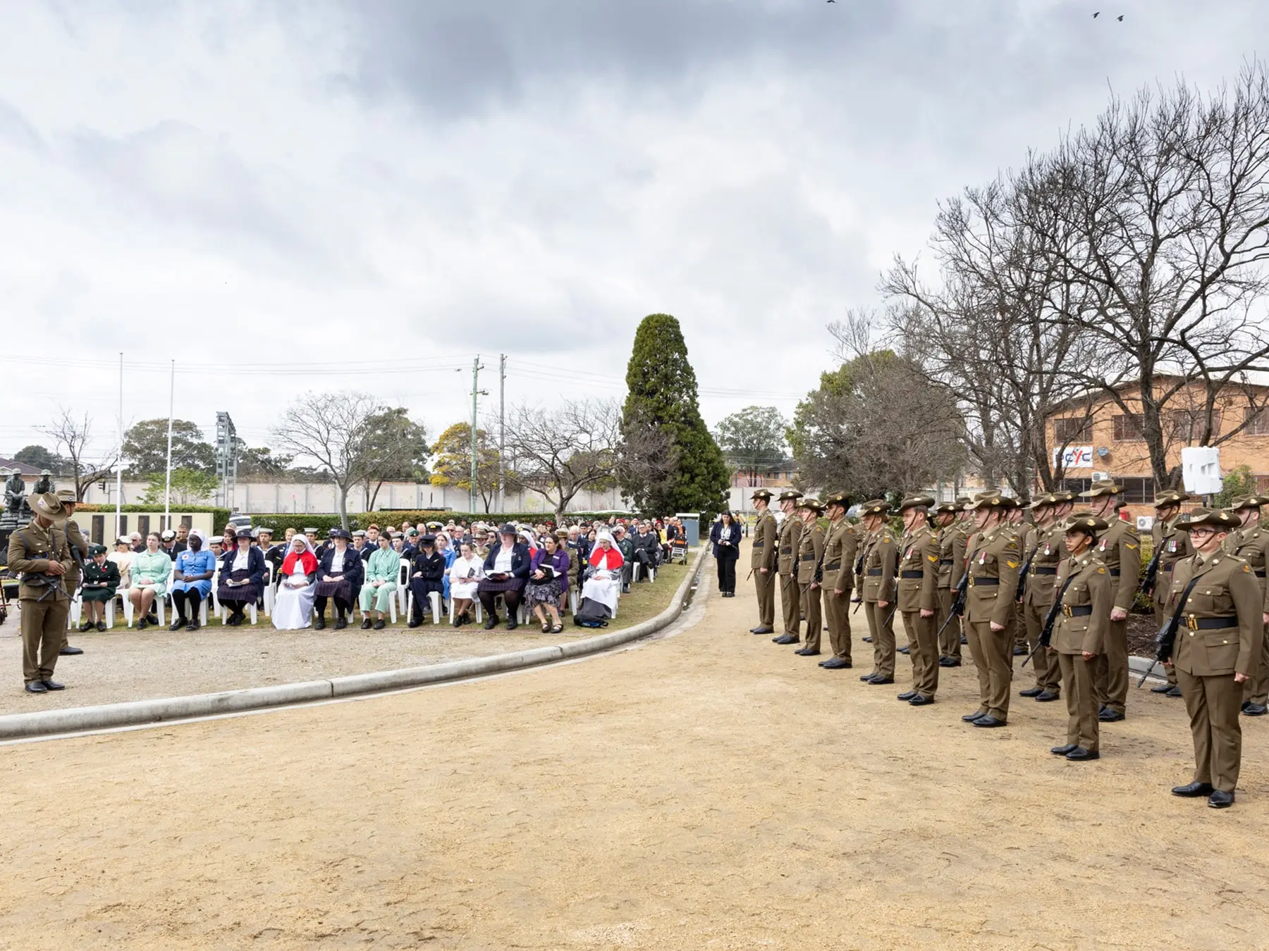 Uniformed Australian Army personnel stand in formation during the Victory in the Pacific Commemoration Service at Cabravale Memorial Park, facing seated veterans, clergy, and community members.