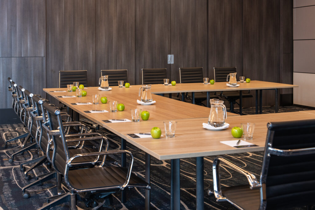 U-shaped conference table set with water and notepads for a meeting at the Cabravale Events & Conference Centre
