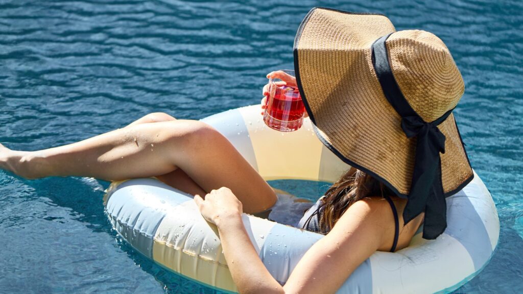 Guest relaxing in the pool with a cocktail at Solaire Lounge