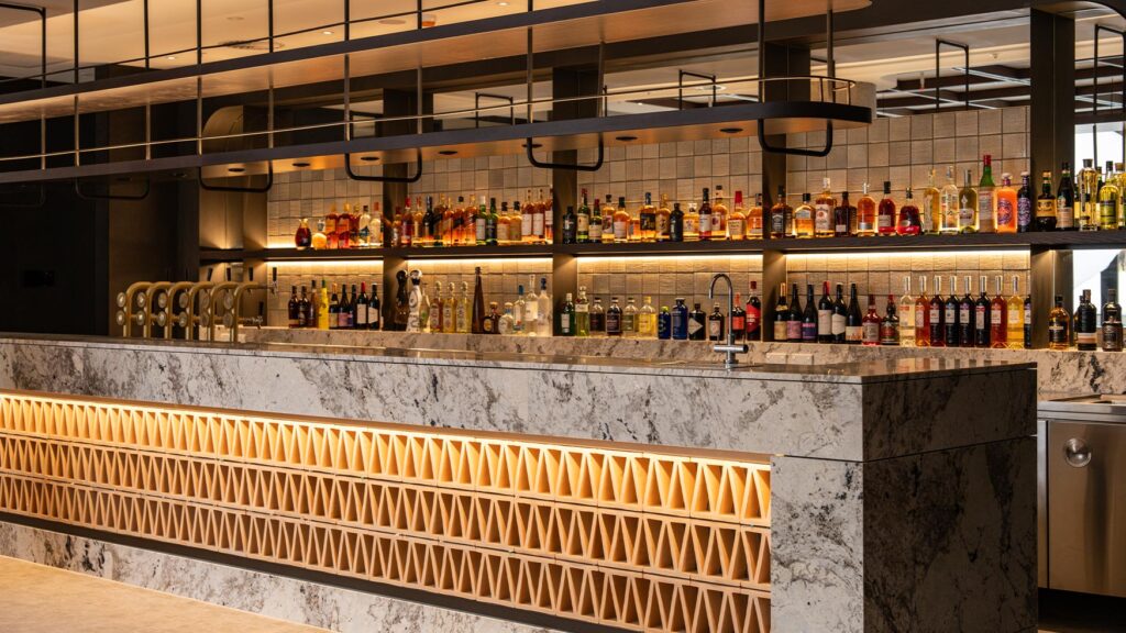 Backlit cocktail bar with premium spirits at Solaire Lounge