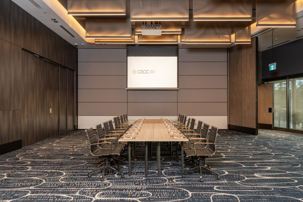Boardroom table facing a presentation screen, ready for corporate events at the Cabravale Events & Conference Centre