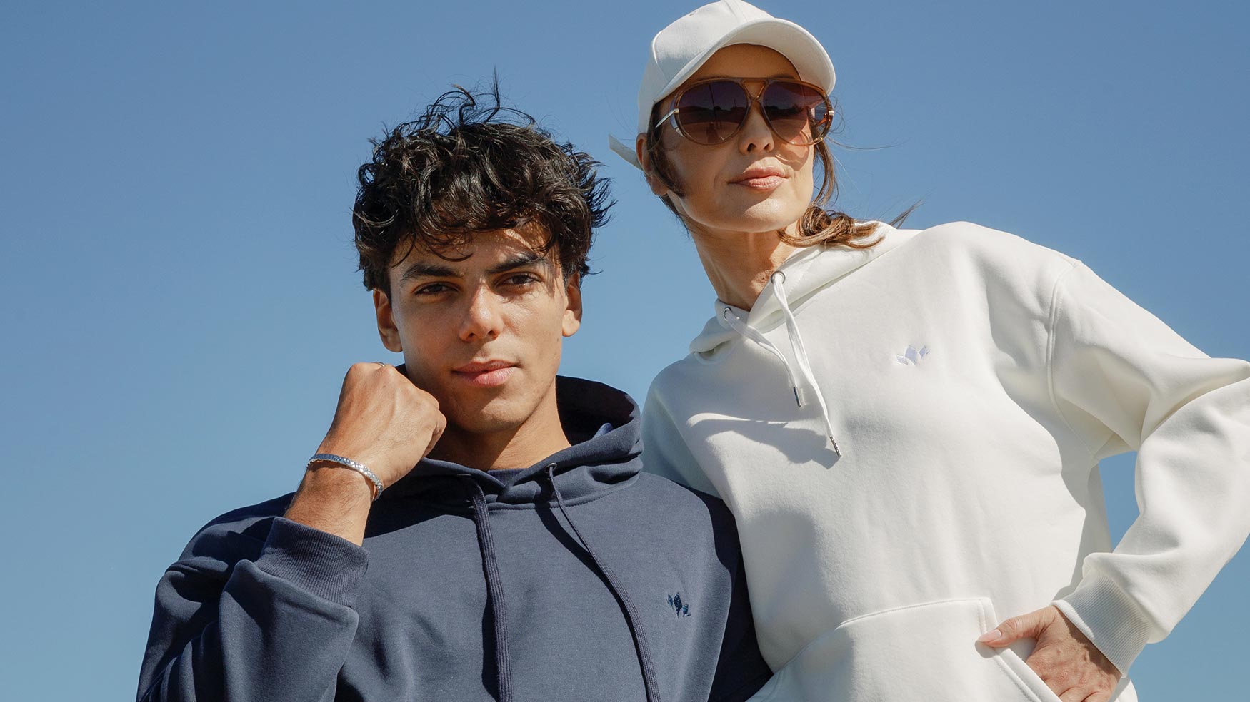 Couple wearing matching Cabravale Boutique navy and white hoodies outdoors