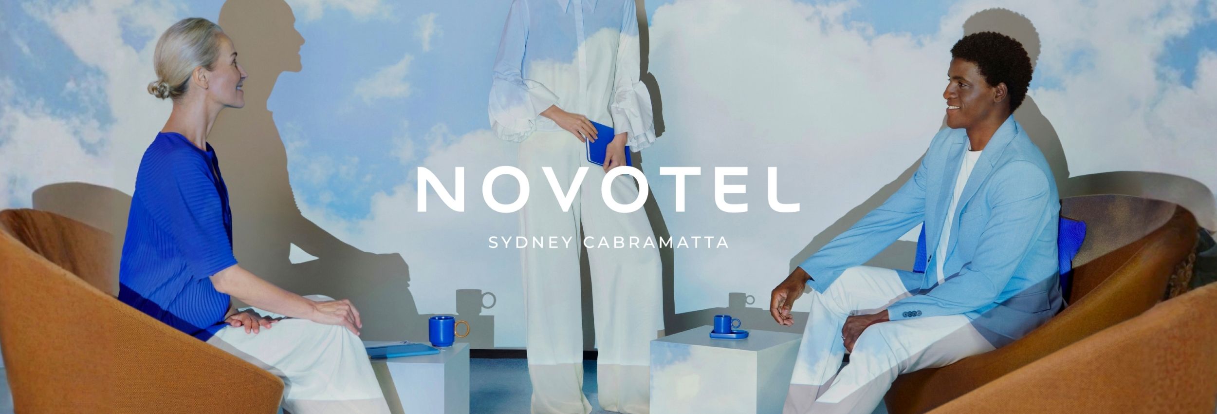 Novotel Sydney Cabramatta corporate events lounge setup with two business attendees in armchairs and sky backdrop