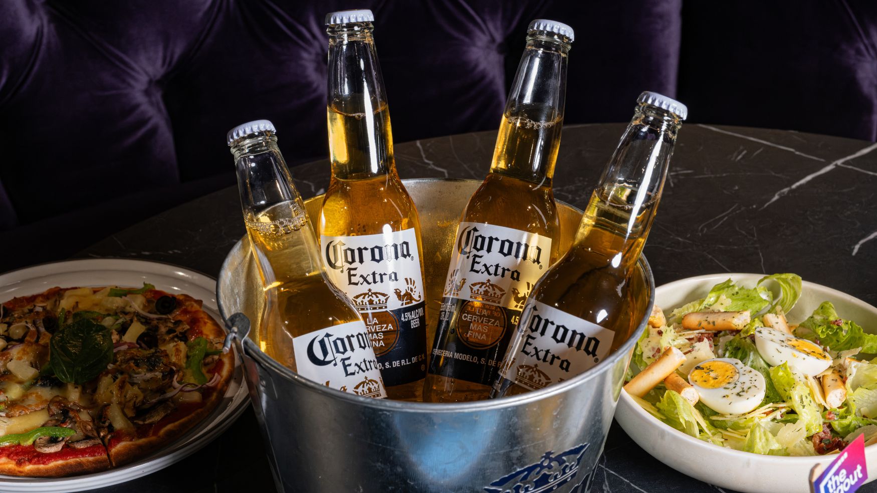 dugout food carousel with bar food and pizza, salad. fish tacos and beer bucket