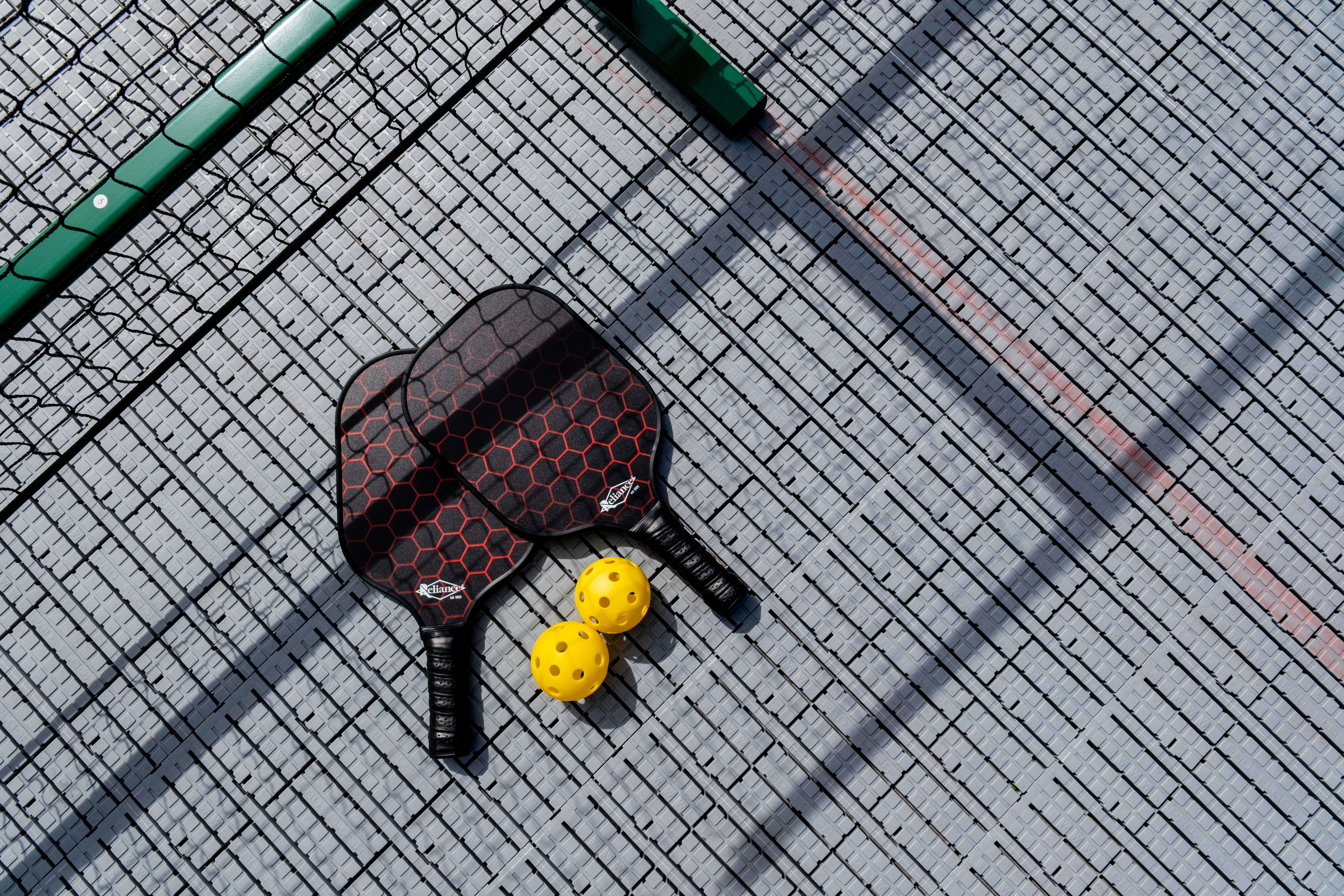 Pickleball paddles and balls on outdoor pickleball court in Western Sydney